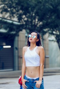 Mulher oriental com óculos, camiseta e calça baixa, no dia fértil